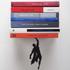 The Superhero Bookshelf by Artori Design is an innovative floating bookshelf that would suit any superhero fan. The clever design makes your books appear as though they are being held up by your very own caped crusader.  The bookshelf hangs on the wall easily with two screws. Insert the shelf between a book cover and the last page of a paperback book. Attach the magnetic superhero hand to your wall whilst holding the book cover close to the shelf. As books are stacked higher the shelf will become completely covered and give the impression that your books are floating in air!  Features:    Artori Design Super Hero Book Shelf  Innovative floating bookshelf  Books appear as though being held by superhero  Max. weight recommended 3.5kg  Made of black painted metal  Dimensions: L: 13cm x H: 16cm x W: 12cm  Great shelf idea for any superhero fan